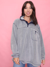 Model wearing a vintage grey 1/4 button fleece with contrast navy collar and chest pocket. Cosy unisex outdoorswear.