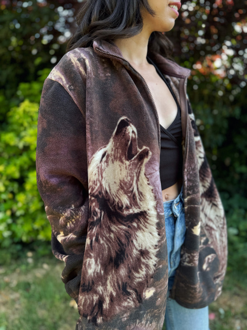 Make a wild statement with this Vintage Wolf Patterned Zip-Up Fleece Jacket, featuring an all-over wolf and nature motif that captures the rugged spirit of the outdoors. Crafted from ultra-soft fleece, this cozy jacket combines 90s novelty print energy with everyday comfort.

A must-have for fans of animal print vintage, grunge, or gorp-inspired looks. Whether you're layering up for a forest walk or turning heads downtown, this fleece is rare, bold, and endlessly wearable.
