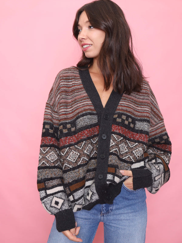 Model wearing a vintage Hugo Boss wool blend cardigan with bold geometric knit patterns and button-up front.
