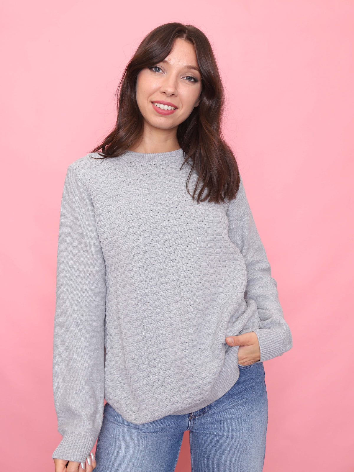 Model wearing a 90s vintage light grey knit jumper with a textured front pattern – minimalist unisex sweater.