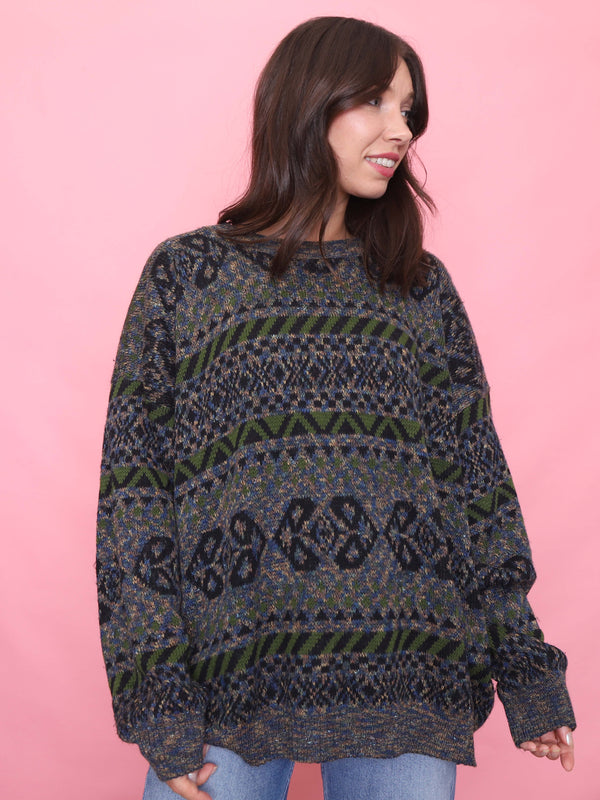 Model wearing a vintage patterned knitted jumper in blue, green, and black – oversized unisex 90s style 