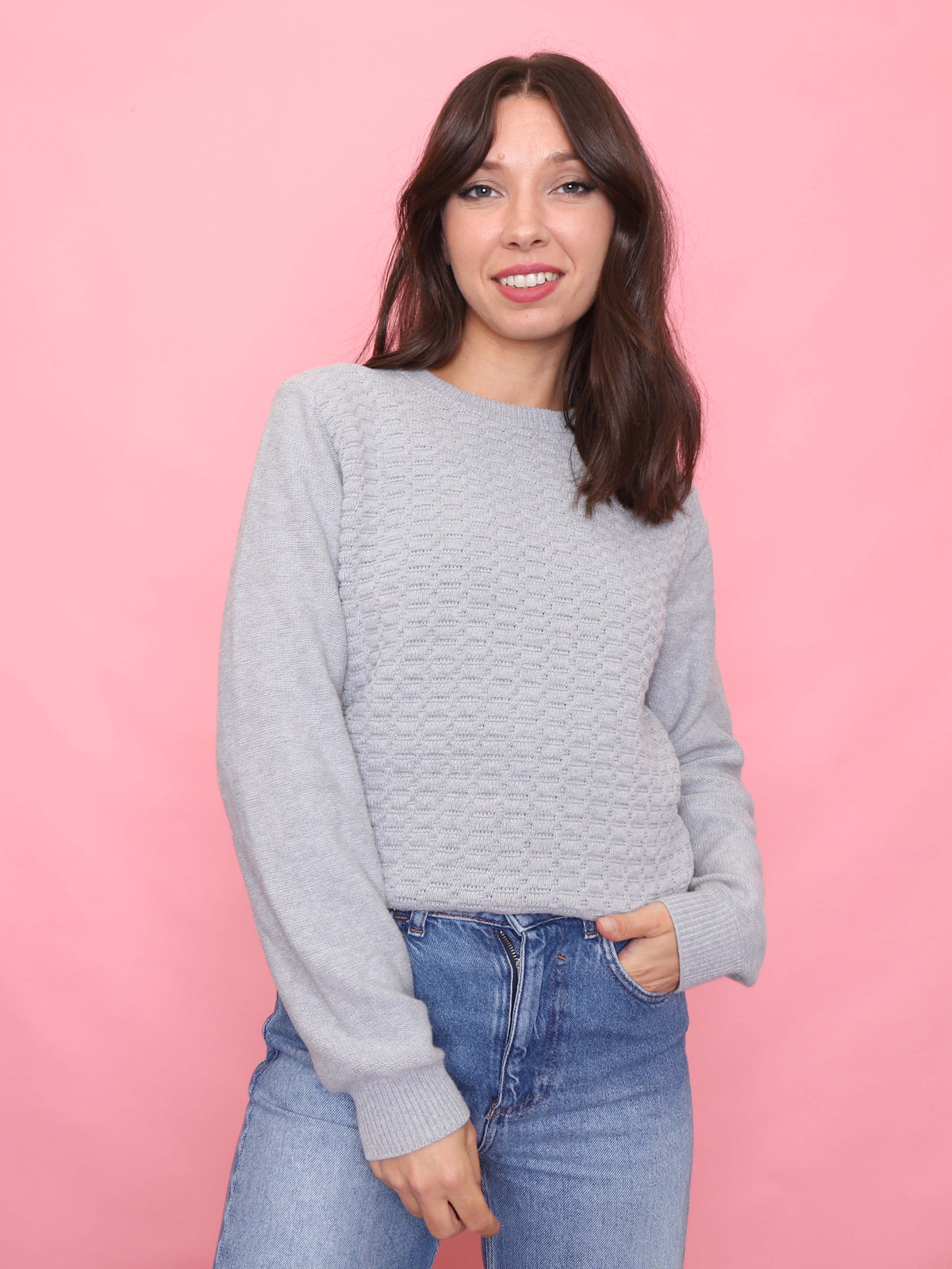 Model wearing a 90s vintage light grey knit jumper with a textured front pattern – minimalist unisex sweater.