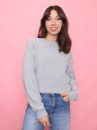 Model wearing a 90s vintage light grey knit jumper with a textured front pattern – minimalist unisex sweater.