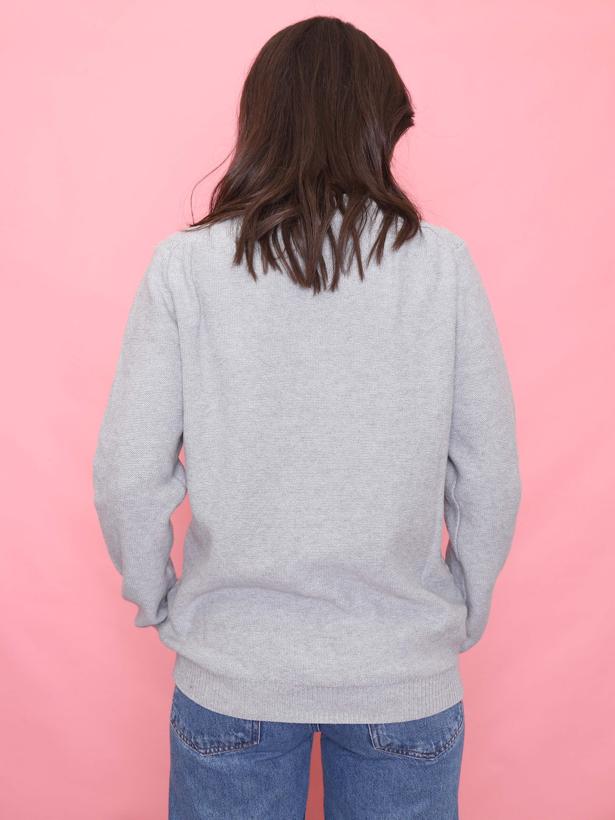 Model wearing a 90s vintage light grey knit jumper with a textured front pattern – minimalist unisex sweater.
