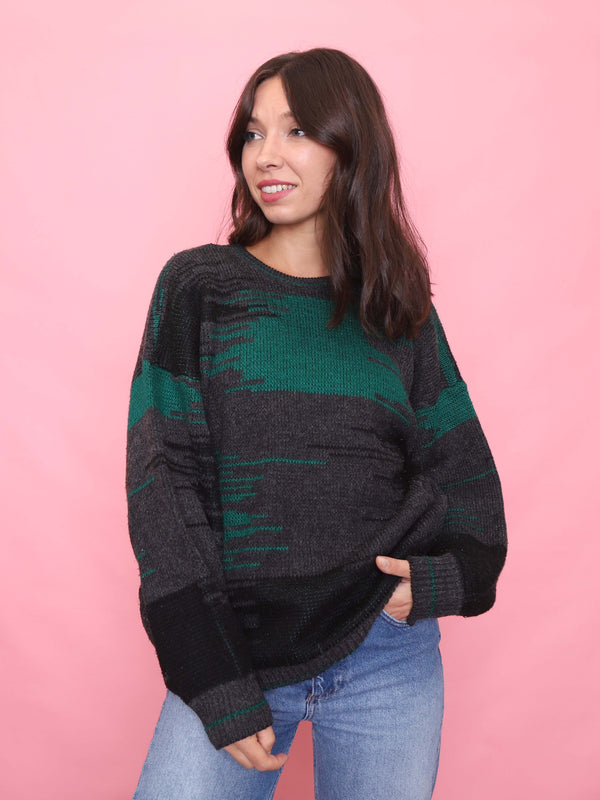 Model wearing a vintage 90s charcoal knit jumper with abstract green and black pattern – unisex retro sweater.