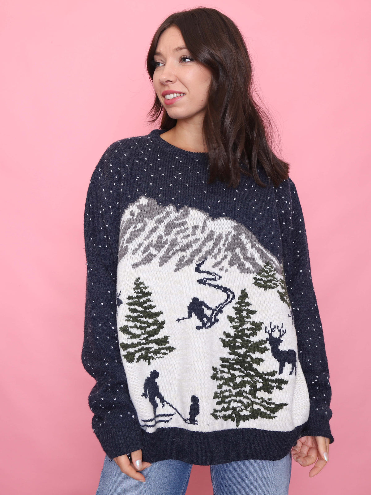 Woman wearing a navy vintage ski scene jumper with snowy mountain and skier pattern

