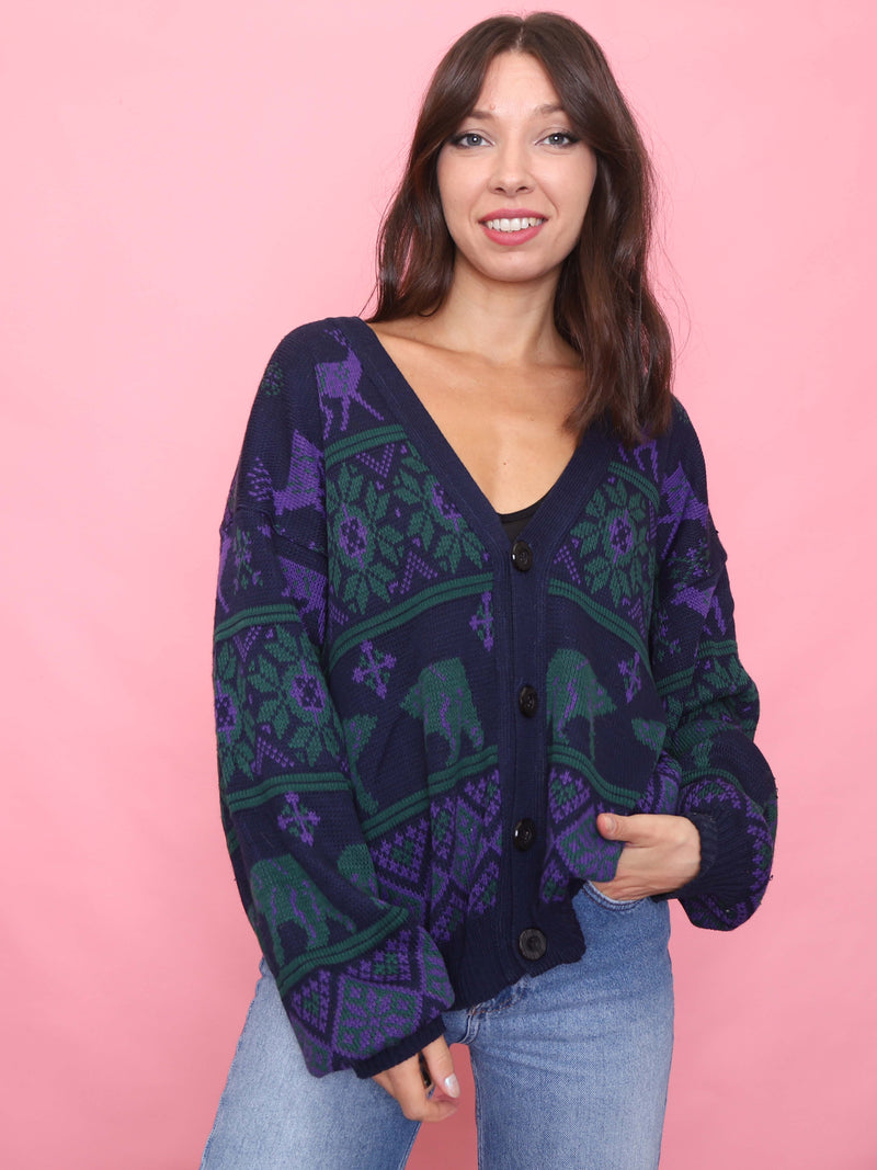 Model wearing a navy vintage knit cardigan with green and purple animal and geometric pattern