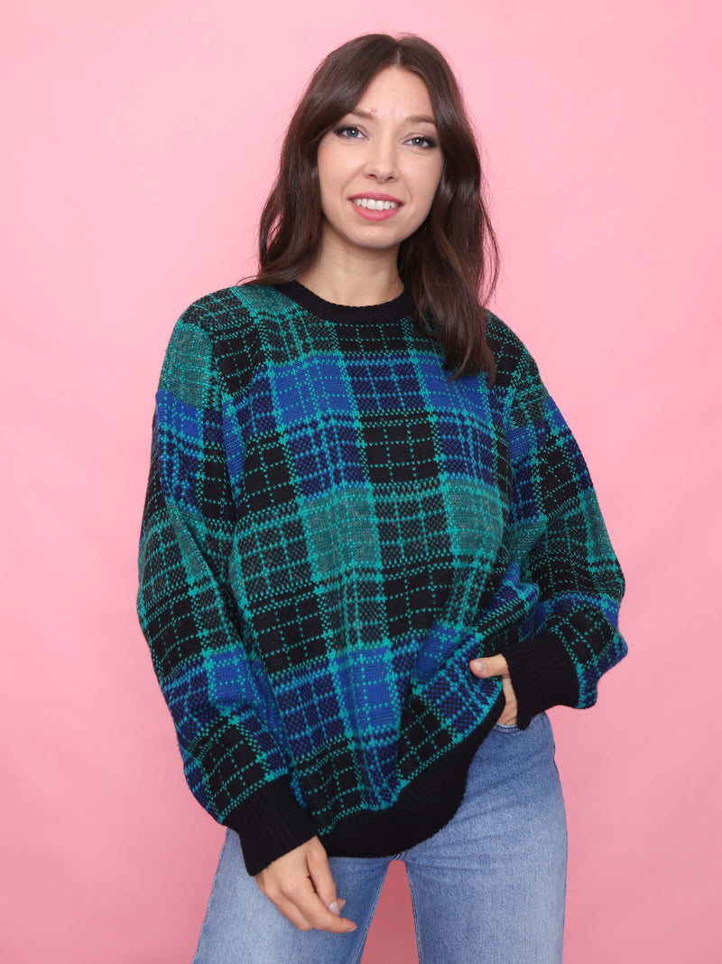 Woman wearing a blue and green vintage tartan knit jumper with relaxed fit

