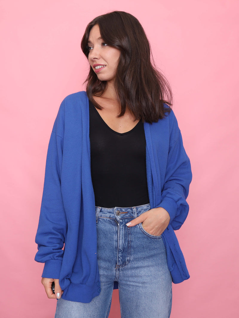 Model wearing a vintage royal blue button-up cardigan over black top and jeans


