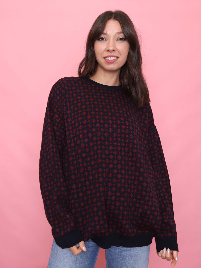 Woman wearing a black vintage jumper with burgundy diamond knit pattern and relaxed fit

