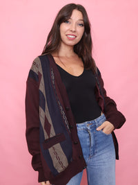 Model wearing a vintage burgundy and navy patterned knit cardigan with argyle detailing and button front

