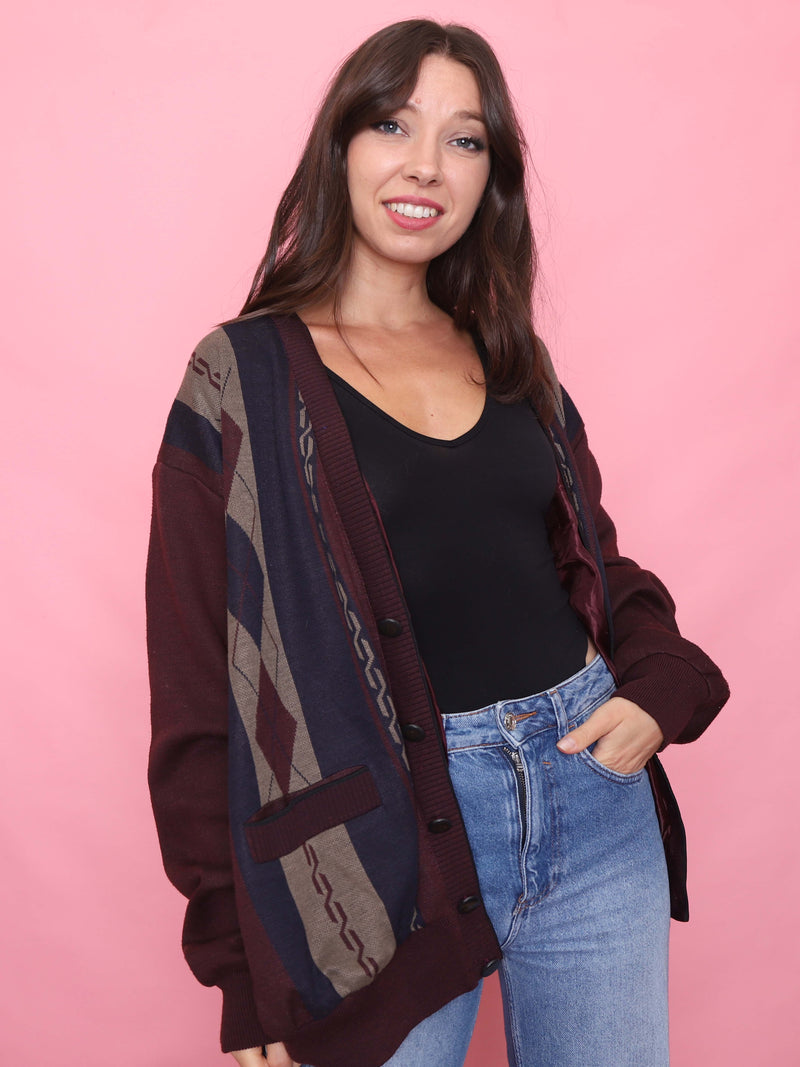 Model wearing a vintage burgundy and navy patterned knit cardigan with argyle detailing and button front

