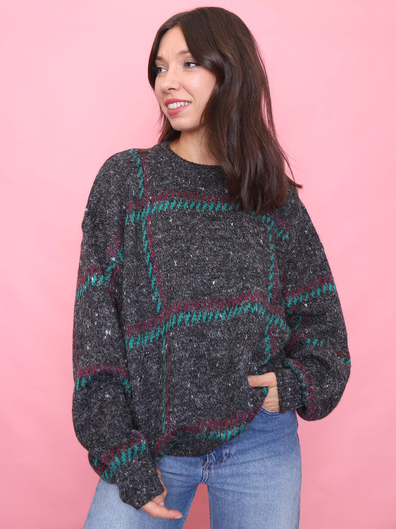Model wearing a vintage 90s charcoal grey jumper with teal and burgundy check knit pattern.

