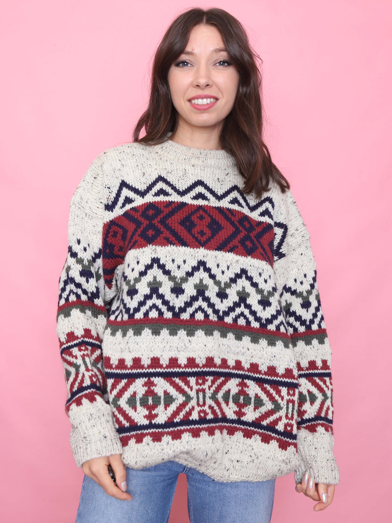 Model wearing a vintage chunky knit wool jumper with Nordic Fair Isle pattern in cream, navy, red and green