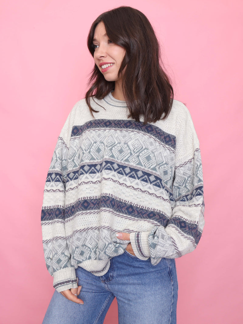 Woman wearing a vintage cream and blue patterned knit jumper with relaxed fit and soft texture

