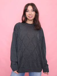 Model wearing a vintage dark grey jumper with subtle diamond knit texture and oversized fit.

