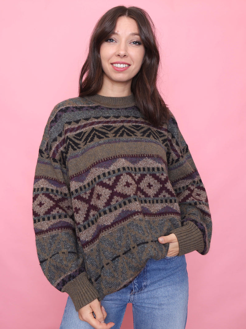 Model wearing a vintage patterned knit jumper in earthy autumnal tones  burgundy, green and taupe – with a cosy slouchy fit