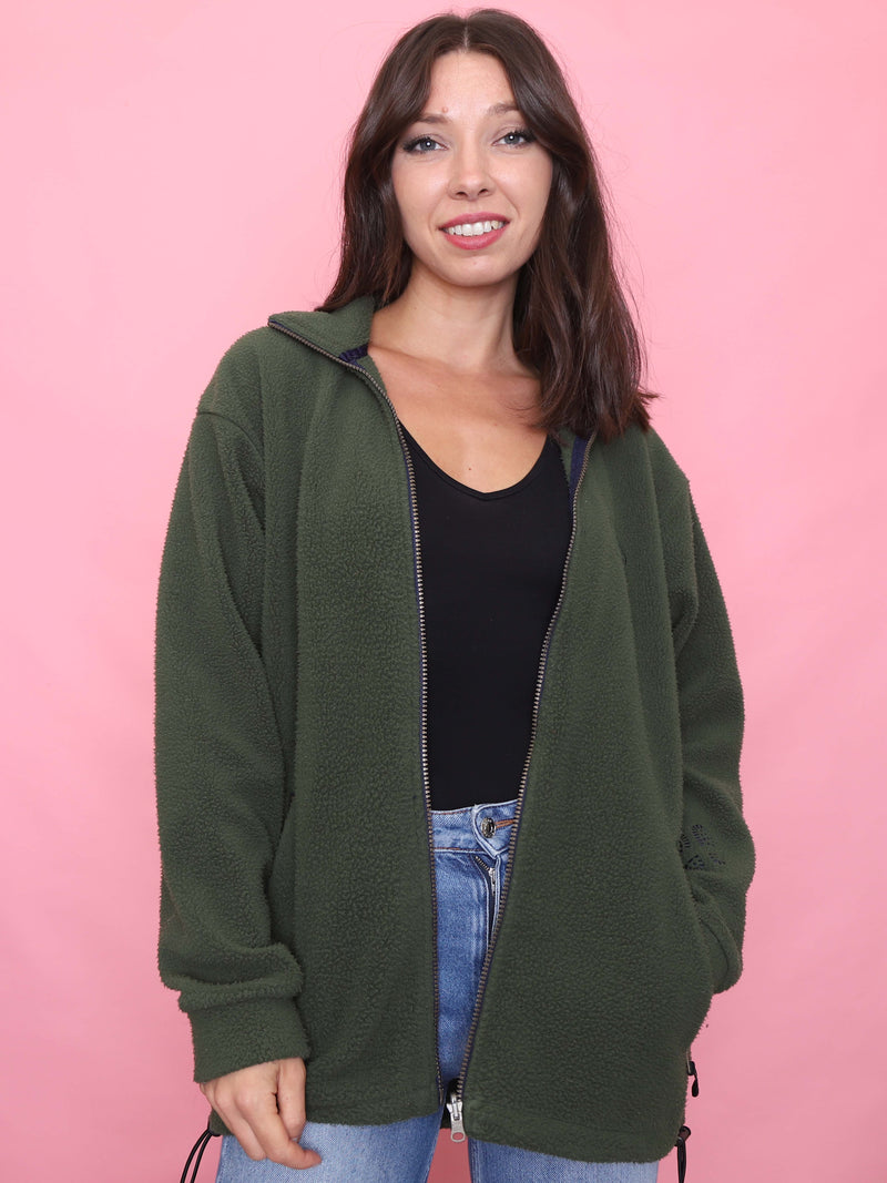 Model wearing a vintage forest green zip-up fleece jacket with drawstring hem – soft outdoor layer.
