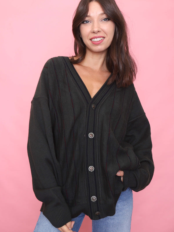 Model wearing a vintage deep olive green knit cardigan with burgundy pinstripe detail, button-up front, and relaxed fit.