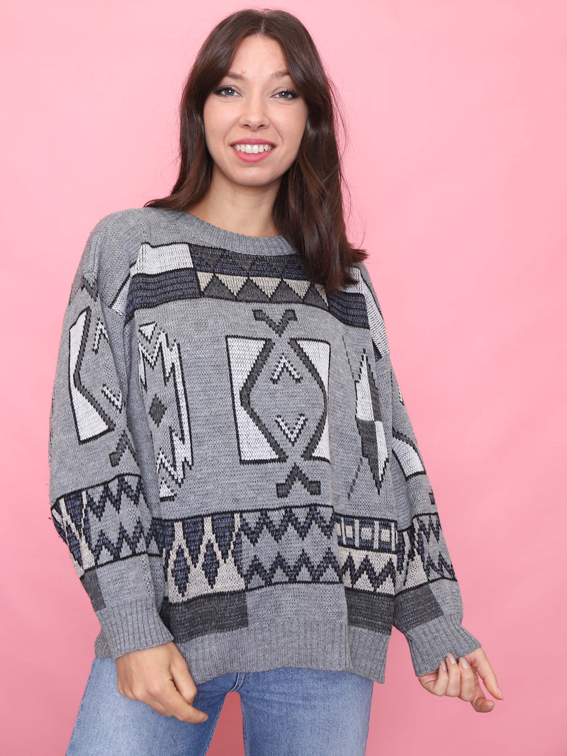 Model wearing a grey vintage knit jumper with black and white Aztec tribal patterns, styled for autumn

