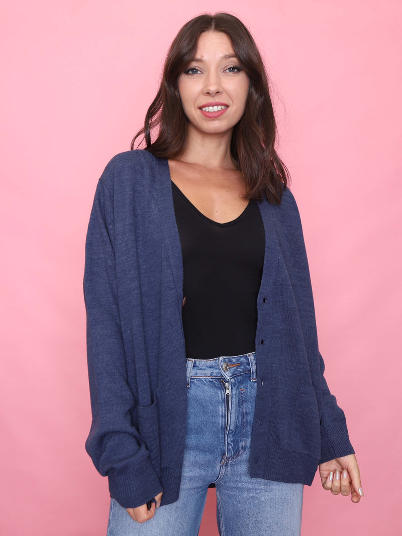 Model wearing a vintage navy blue button-up cardigan with patch pockets and ribbed cuffs

