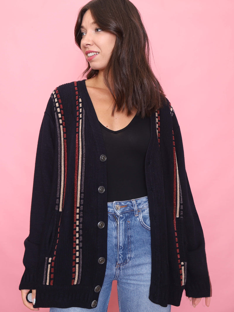 Model wearing a vintage navy knit cardigan with vertical burgundy and tan stripe pattern, oversized fit and button-up front.