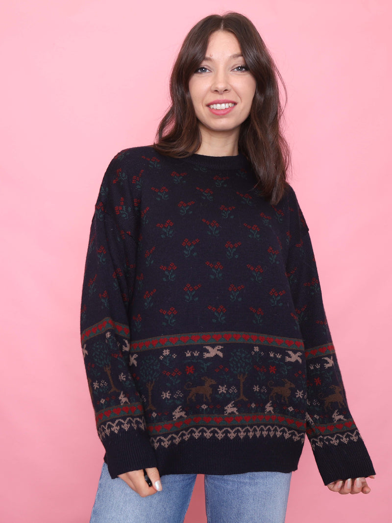 Model wearing a navy vintage jumper with red berries and deer forest pattern, cosy autumn knitwear

