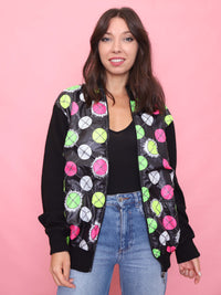 Model wearing a vintage black knit zip-up cardigan jacket with bold neon graphic panels and zippered pockets on the back