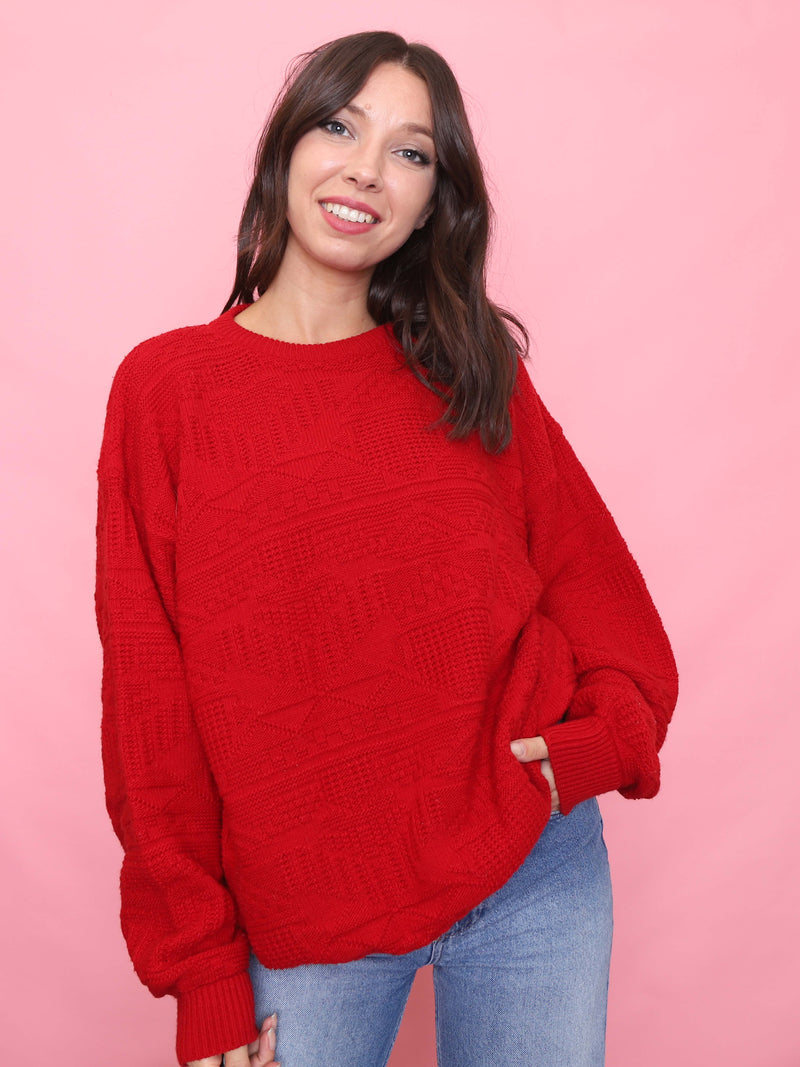 Model wearing a vintage bright red textured knit jumper with geometric pattern

