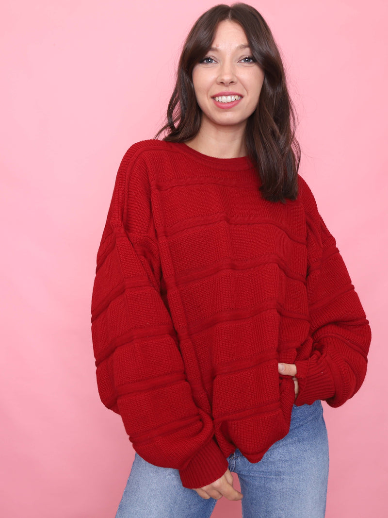 Woman wearing a vintage red pure new wool jumper with chunky knit texture and oversized fit

