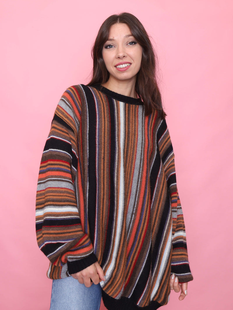 Model wearing a vintage oversized knit jumper with vertical stripes in autumn colours - cosy retro winter sweater


